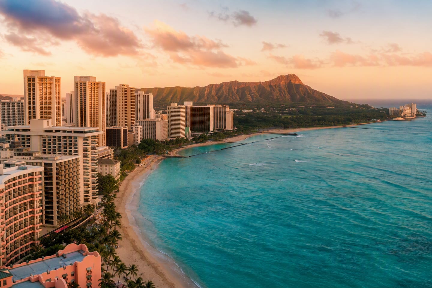Honolulu’s Waikīkī skyline rises behind Diamond Head at golden hour, with the Pacific surf glowing along the palm-fringed beach and no people in the foreground.