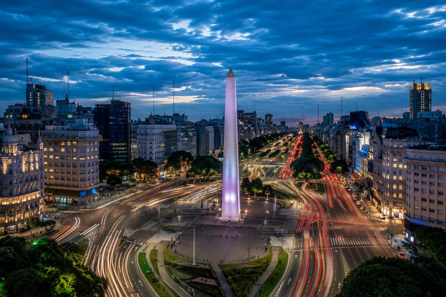 Buenos Aires’ illuminated Obelisk rises above the sweeping lanes of Avenida 9 de Julio at blue hour, framed by the city’s glowing skyline.